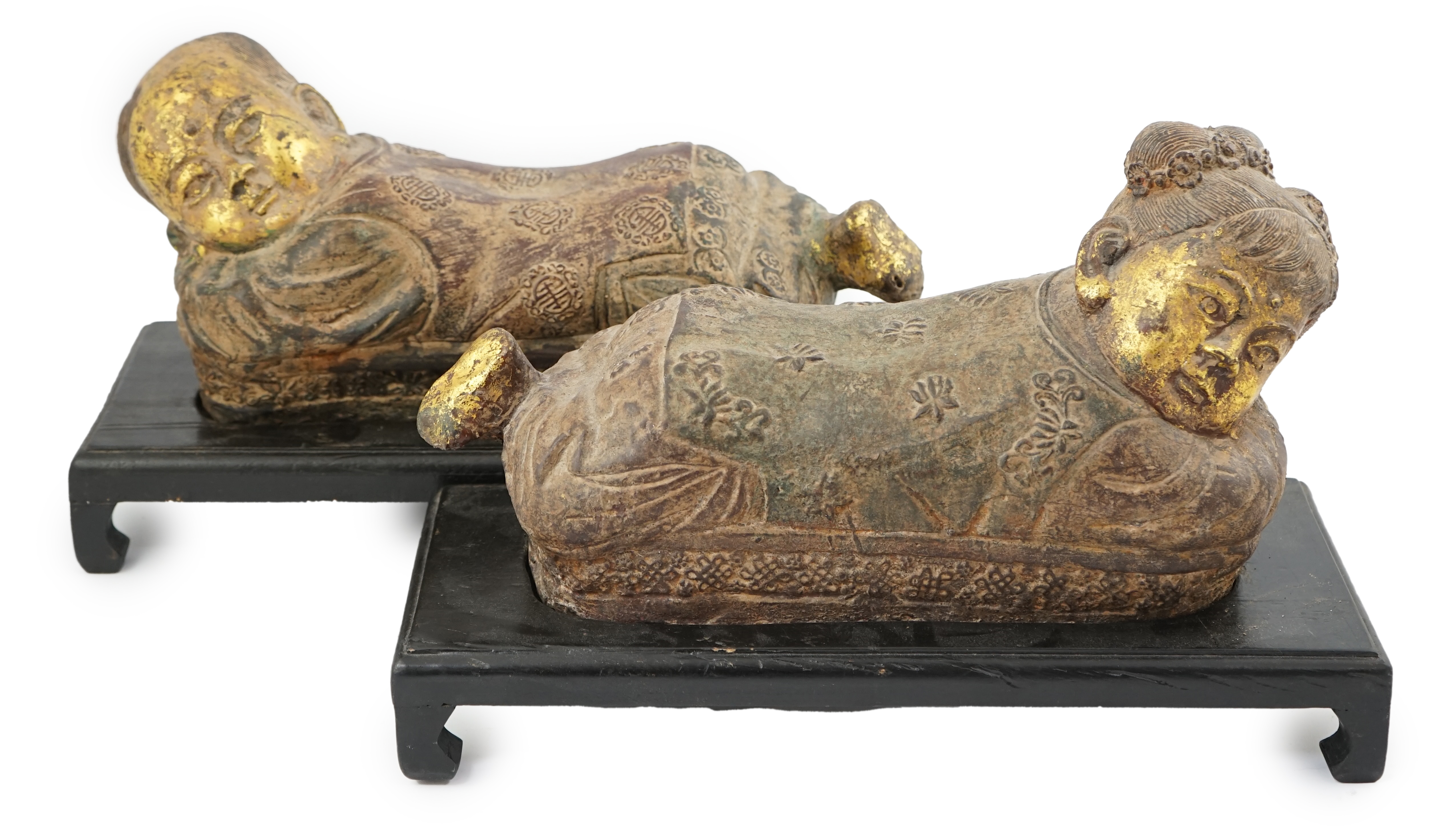 Two Chinese polychrome decorated iron pillows, modelled as sleeping children, on ebonised wood plinths, 44cm long. Condition - fair to good